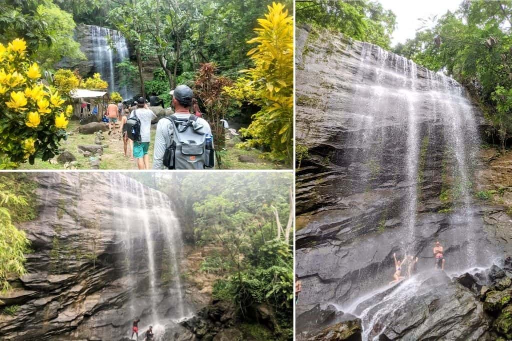 Group of visitors walking up to vast waterfall system, Royal Mt. Carmel falls in Grenada. People standing under the falls surrounded by lush green rainforest.