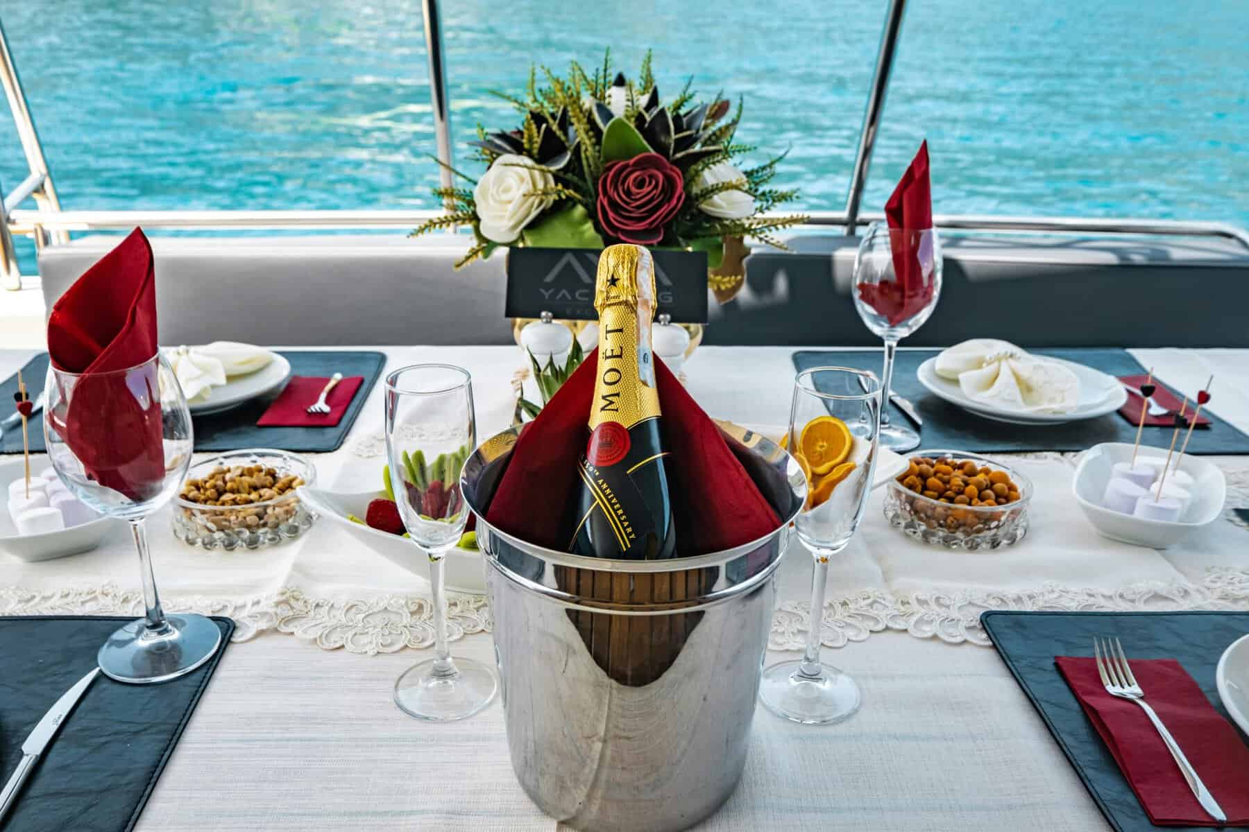 Moet champagne in ice bucket on elegant table with flowers on charter sailboat in the Caribbean