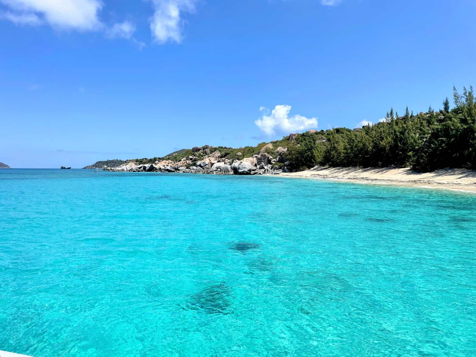Valley Trunk with bright teal blue water and white-sand beach lined with boulders from The Baths British Virgin Islands