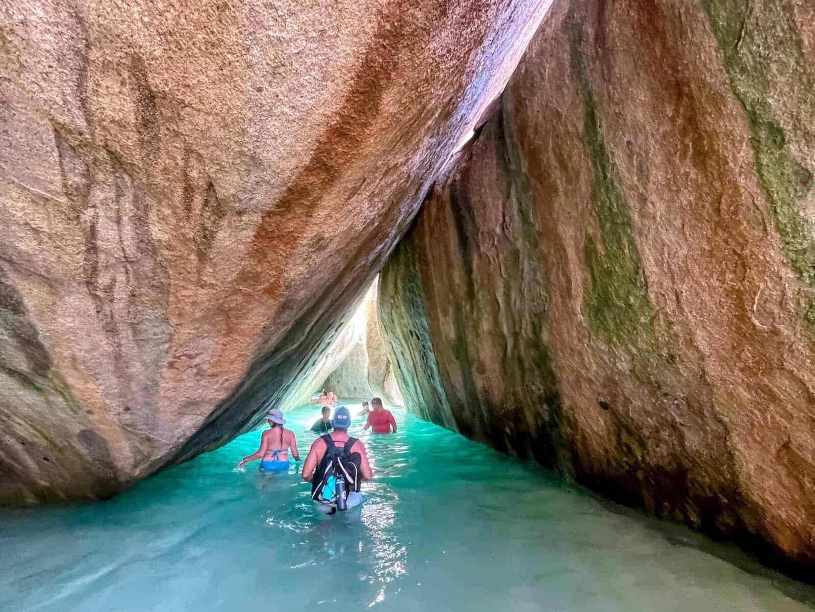 people in bathing suits wading through water in the Cathedral room at the Baths British Virgin Islands