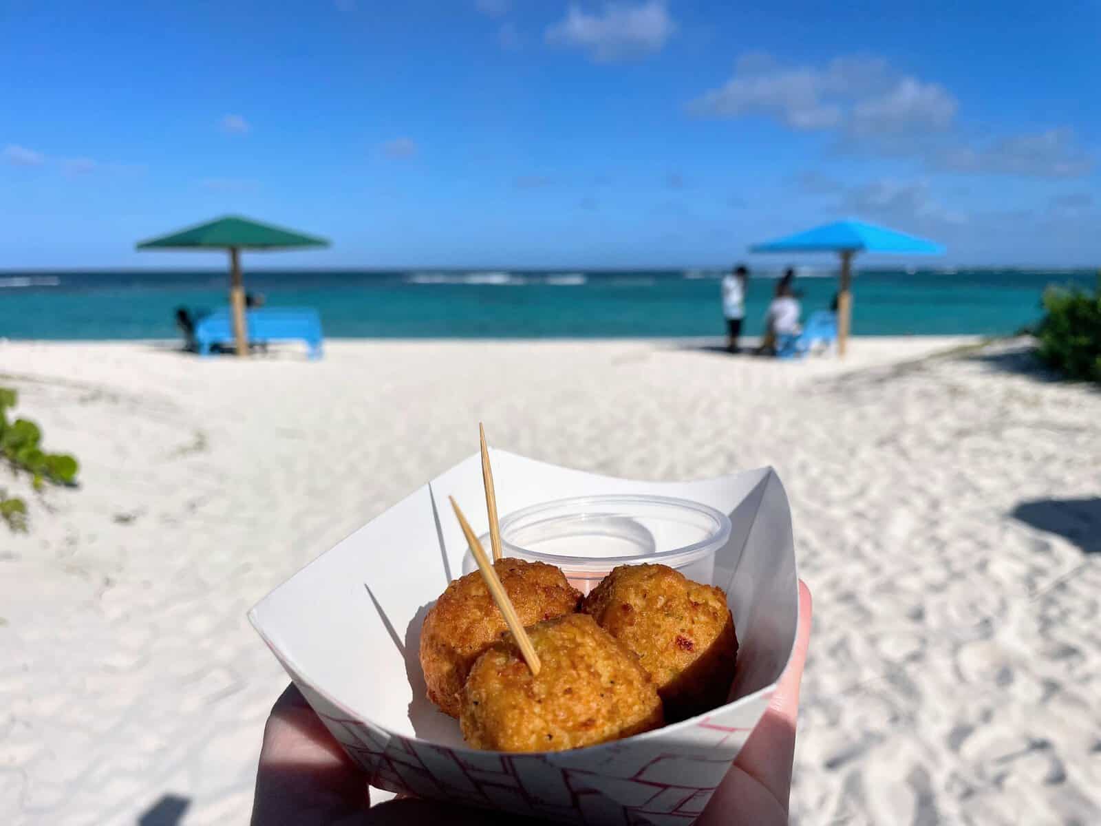 Conch fritters on Anegada with beach and ocean in background