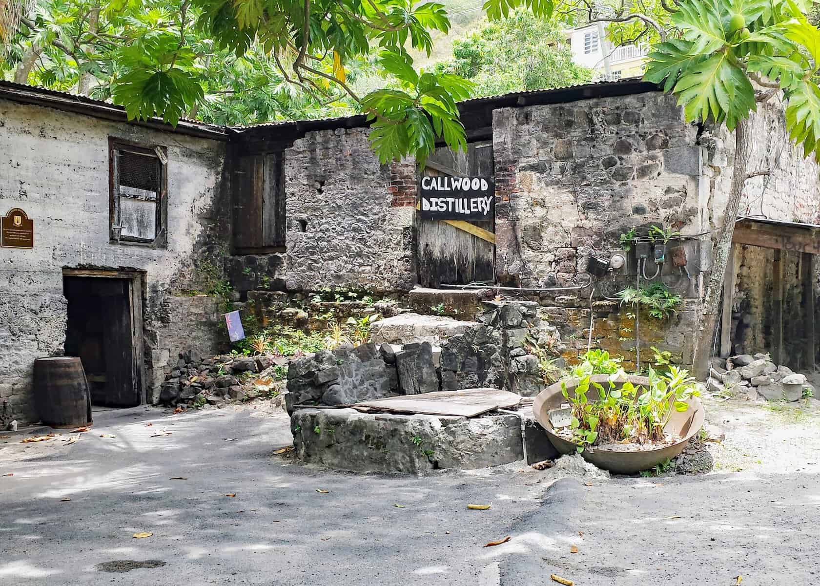 British Virgin Islands Callwood rum distillery. Stone building with papaya trees surrounding it