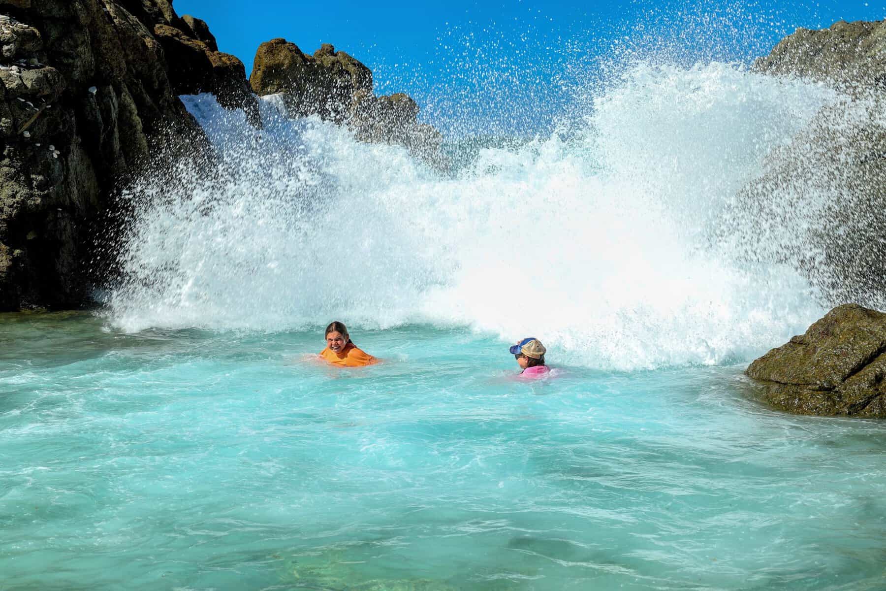 two young girls playing the splashing surf in the British Virgin Islands