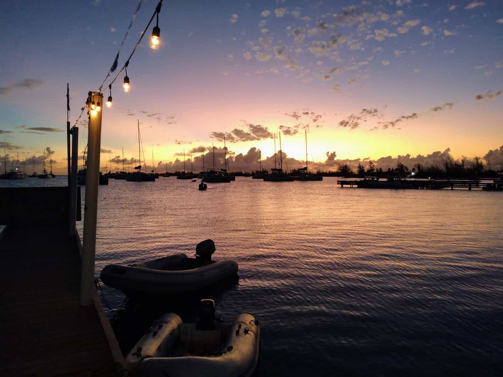 sunset with dinghy tied to dock and sailing catamarans in the British Virgin Islands