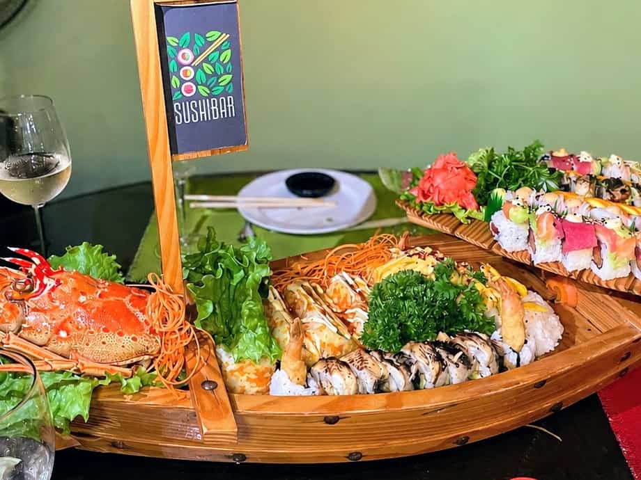 sushi boat loaded with colorful sushi and a glass of white wine in Tortola