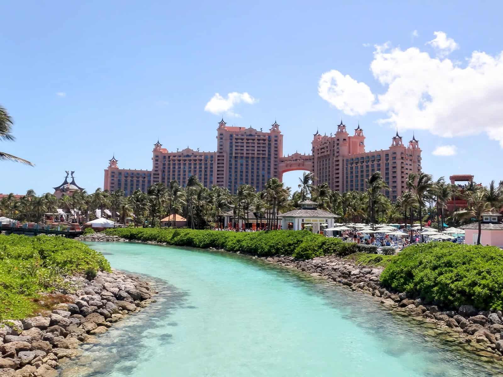 pink Atlantis resort with palm trees and turquoise stream in the Bahamas