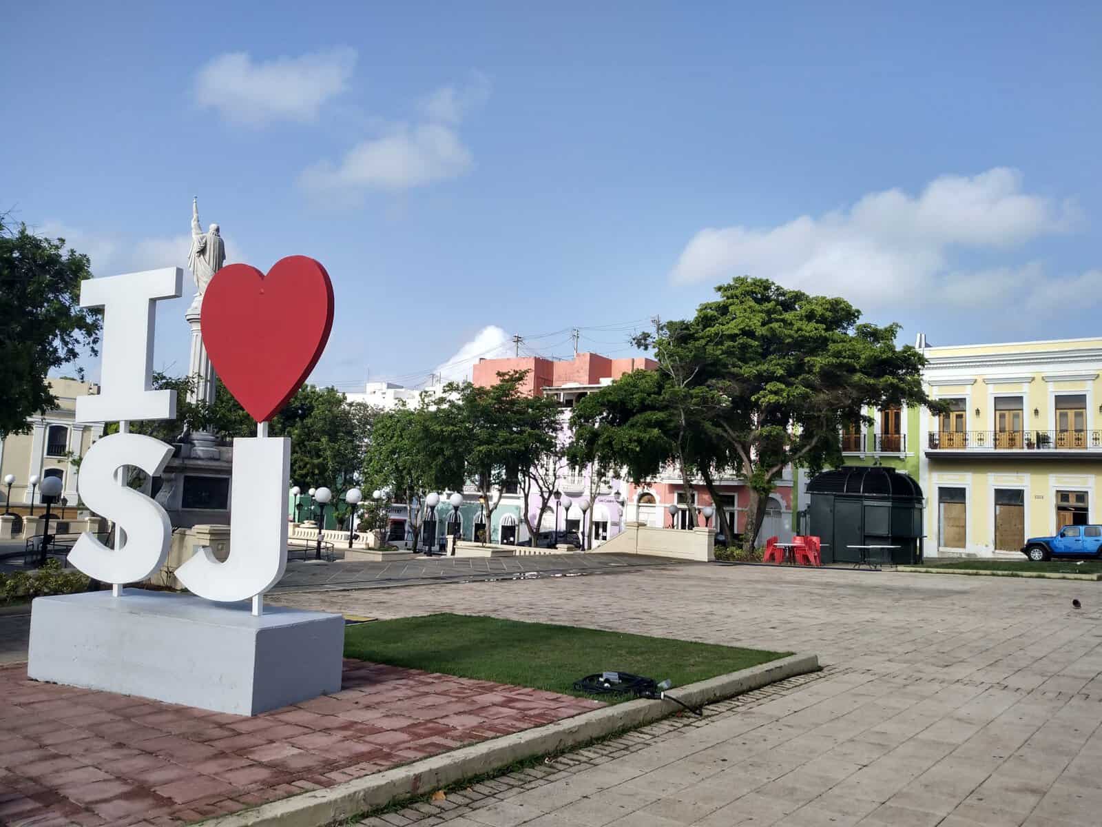 I heart SJ sign in park in San Juan, Puerto Rico with trees and historic buildings in the Caribbean