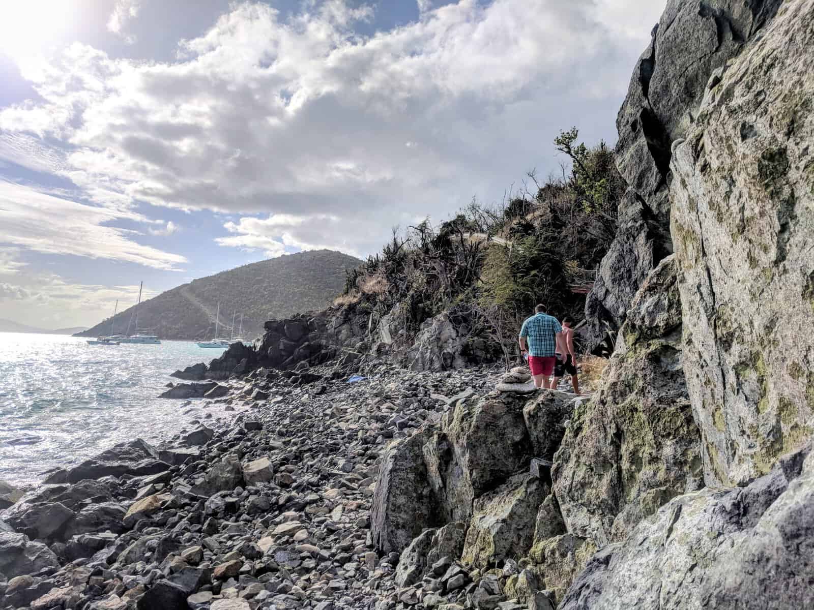 Two guys walking over rocky outcrop between east and west side of White Bay, Jost Van Dyke, British Virgin Islands